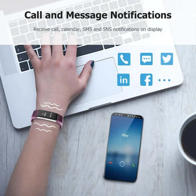 Smart sports bracelet on wrist showing call and message notifications with smartphone and laptop on table