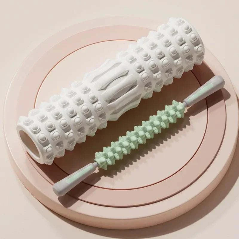 White and green foam muscle massage rollers on beige plate for muscle recovery and fitness therapy